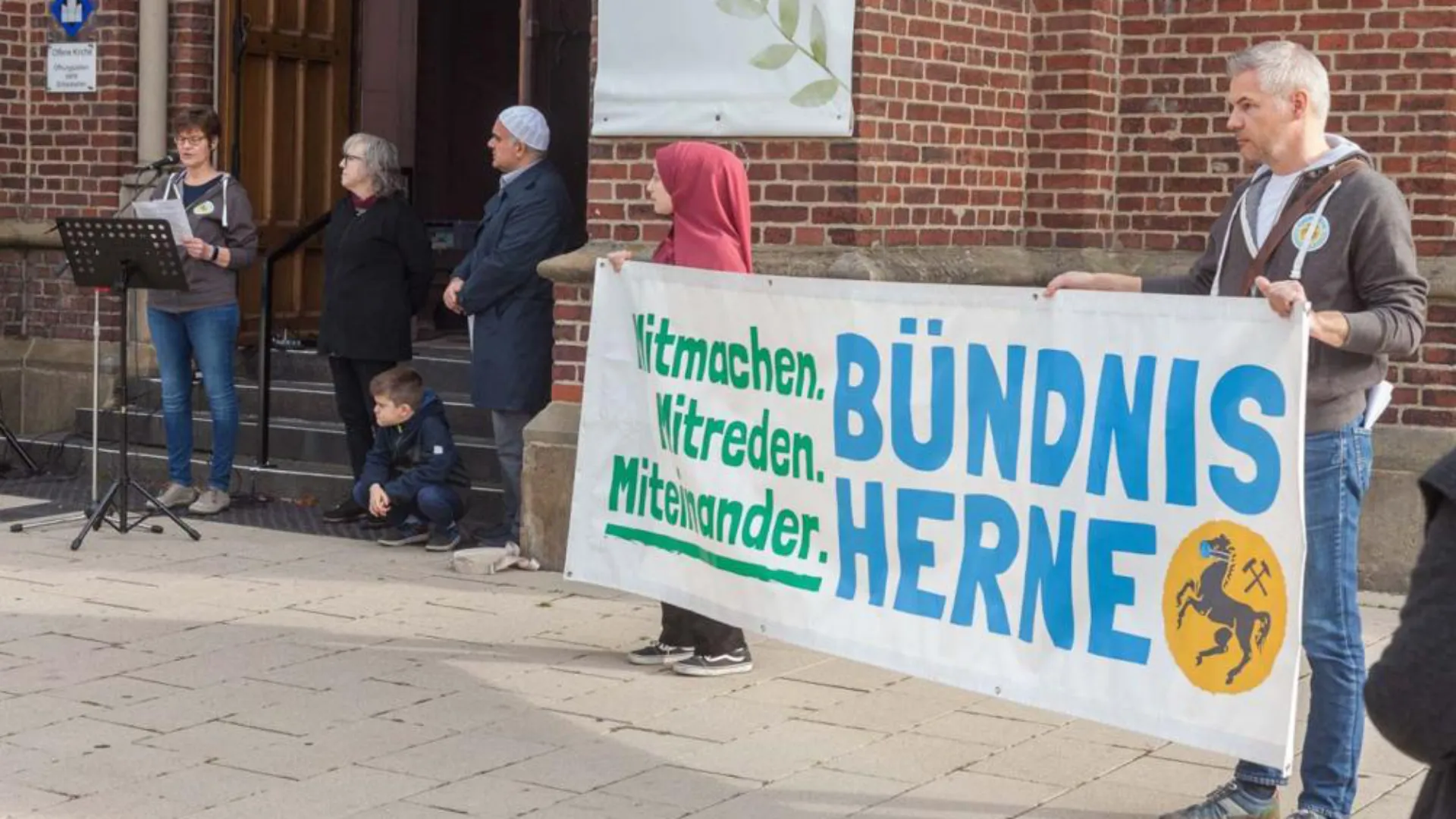 Mitglieder des Bündnis Herne mit Banner vor der Kreuzkirche in Herne